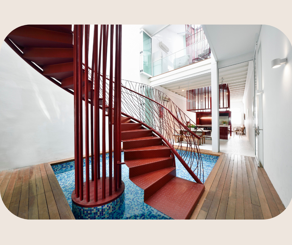 Striking red staircase and shared atrium at Red Dragon House, a heritage shophouse for coliving in Singapore with unique architectural features.