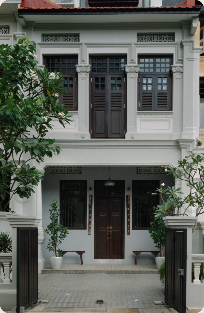 Restored heritage shophouse exterior surrounded by greenery, representing coliving in Singapore through cultural living and historic architecture.