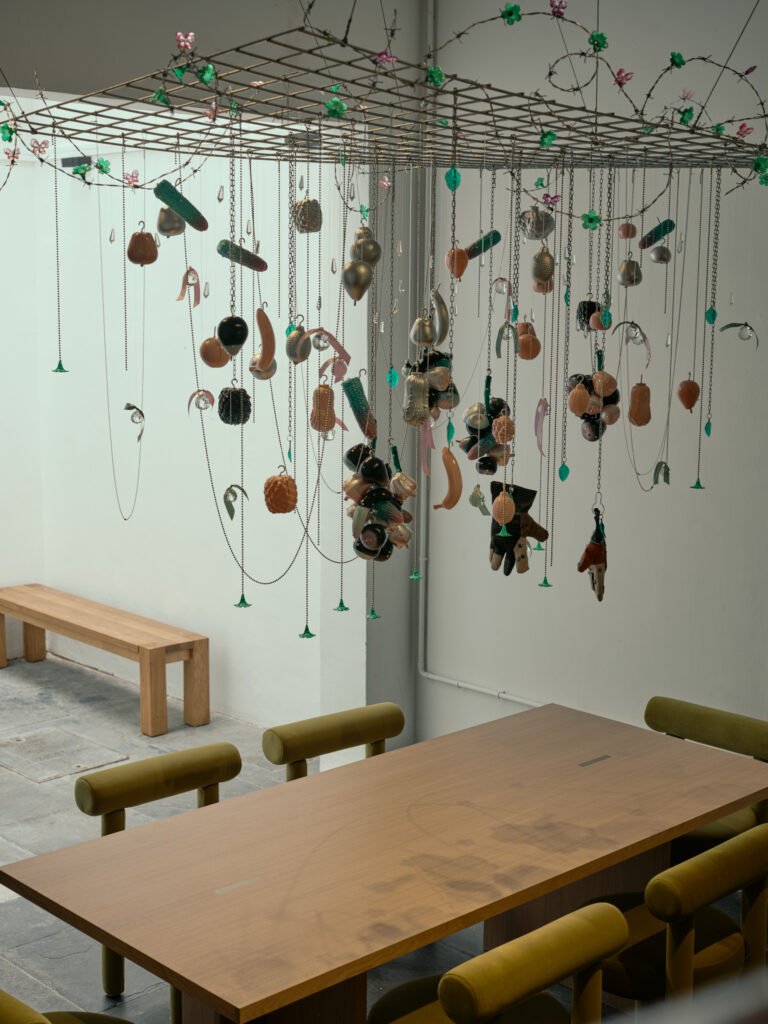 Sculptural dining installation and wooden table showcasing artisan-crafted home design in a modern Figment shophouse.