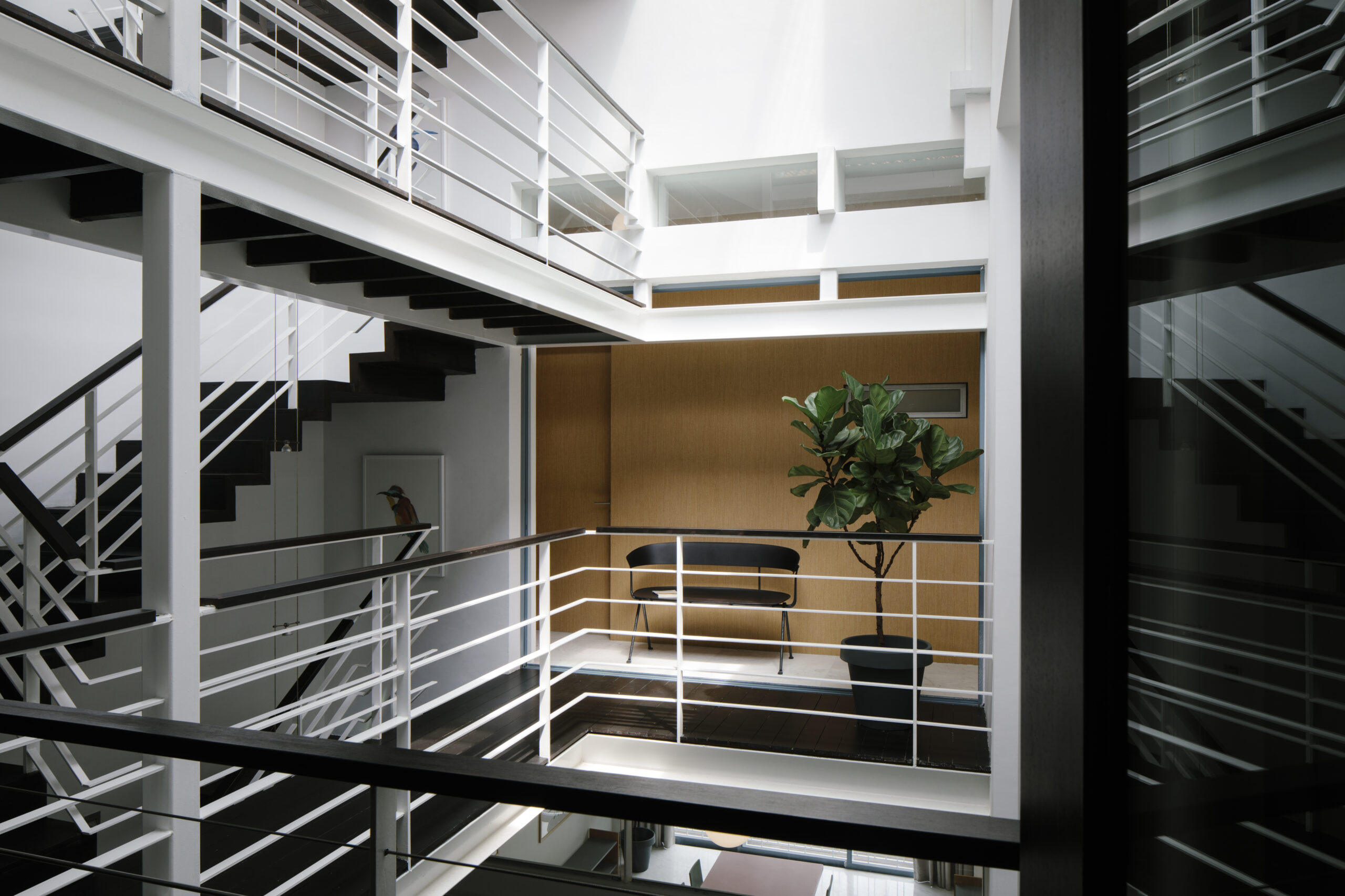 Bright open-air atrium with white staircases in a restored Figment shophouse in a central Singapore neighbourhood